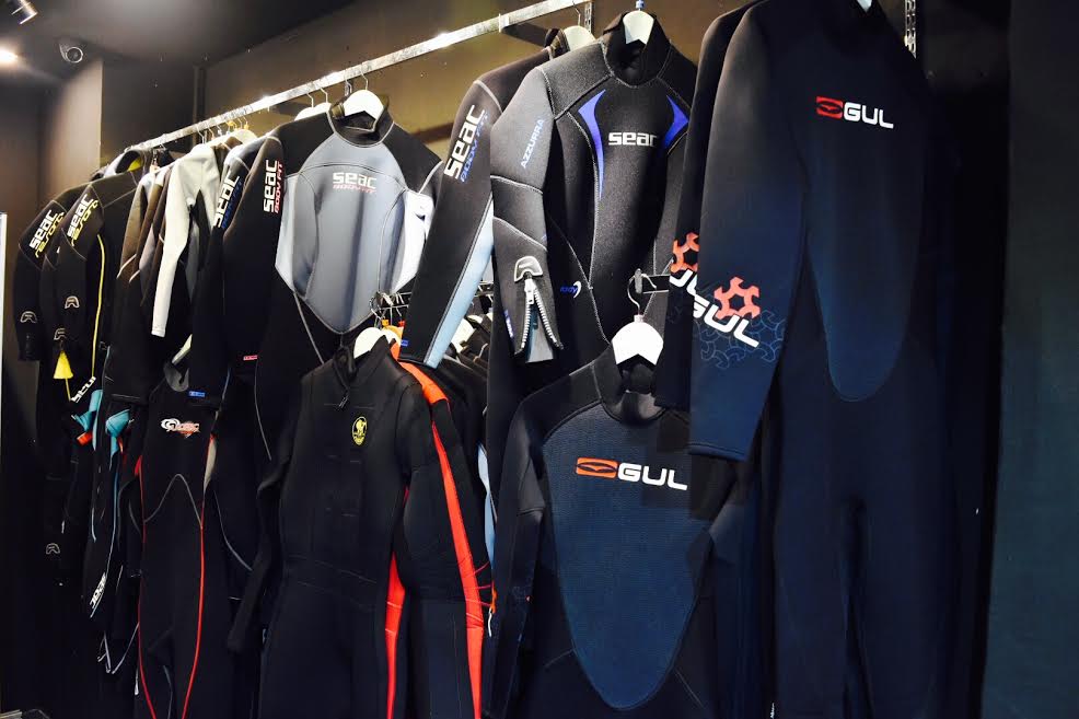 wetsuits hanging on pole